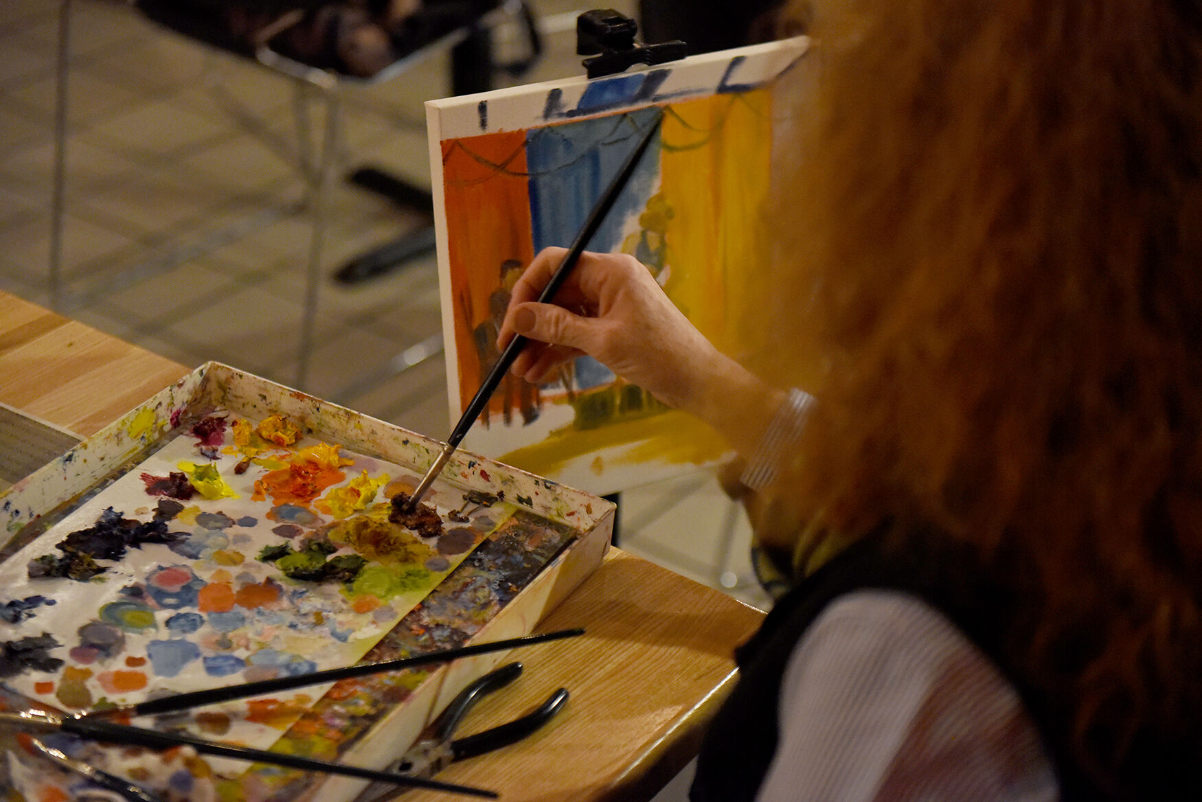 Martha Daniels dips her brush in paint